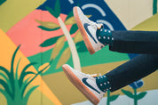 Person wearing nike sneakers against a colorful abstract wall with geometric design mens socks