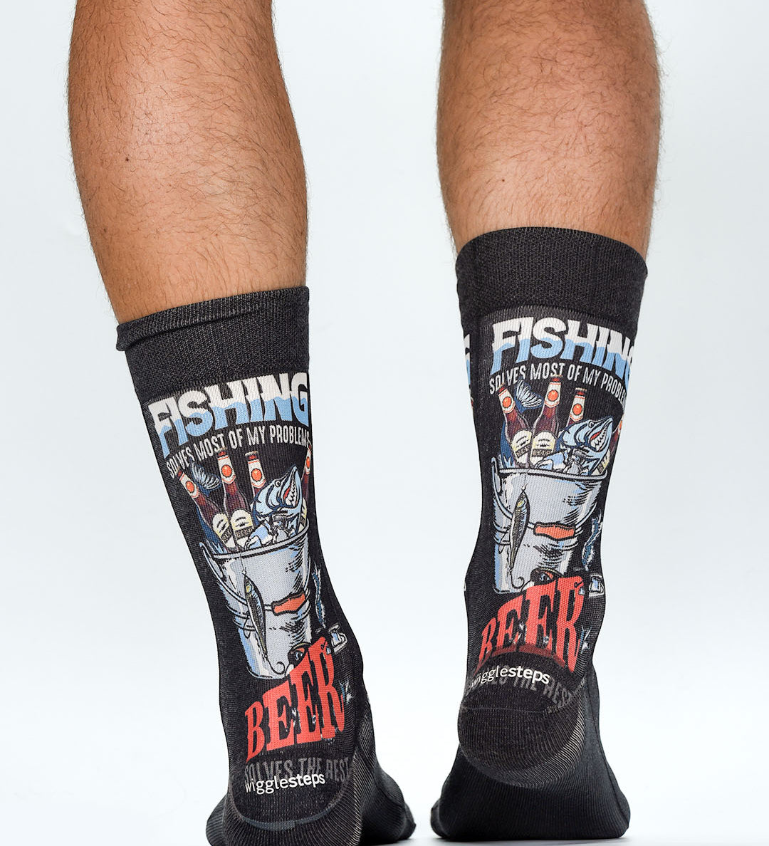 Black socks with fishing and beer-themed designs worn by a person on a white background