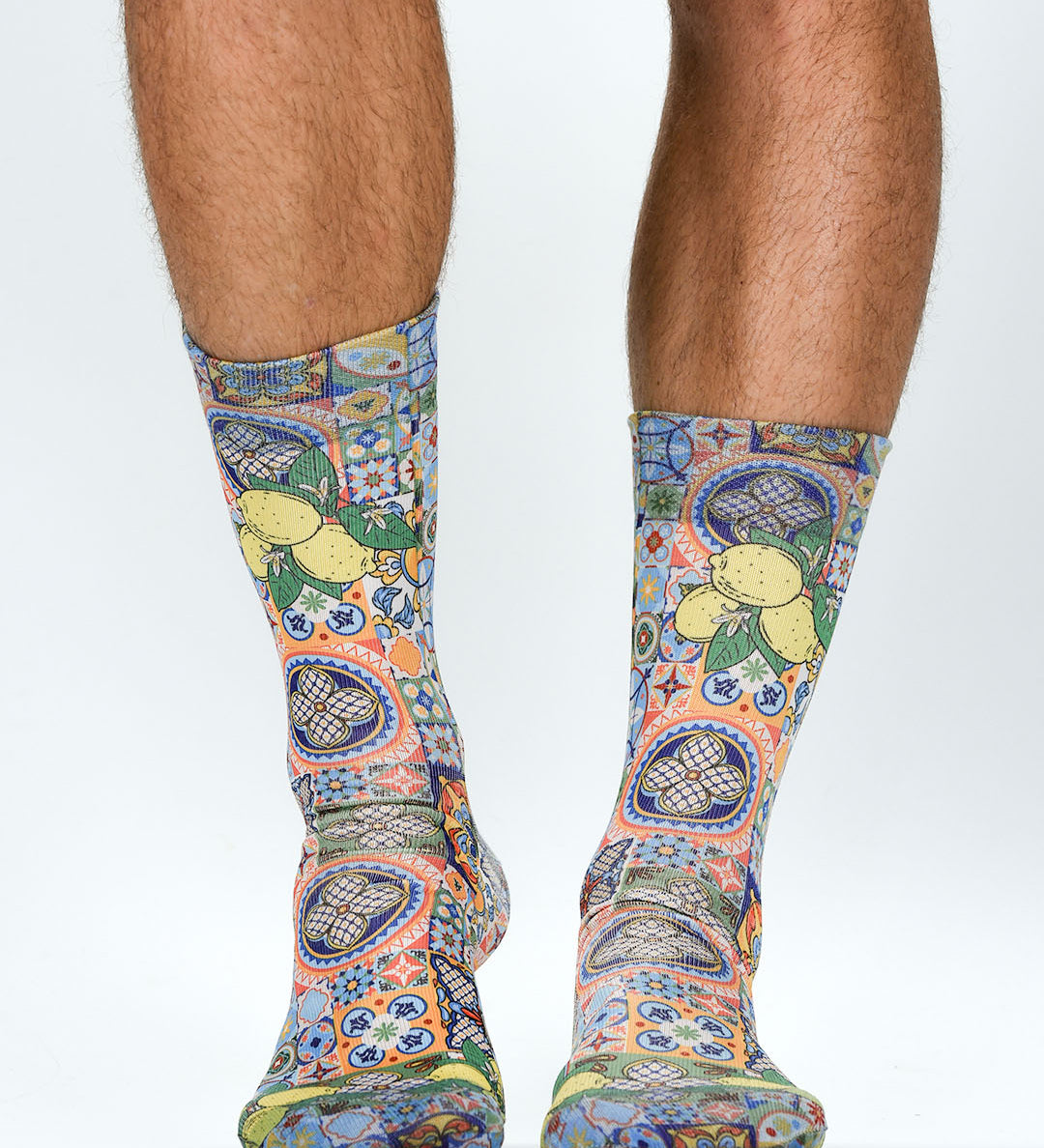 Colorful patterned socks worn by a person on a white background