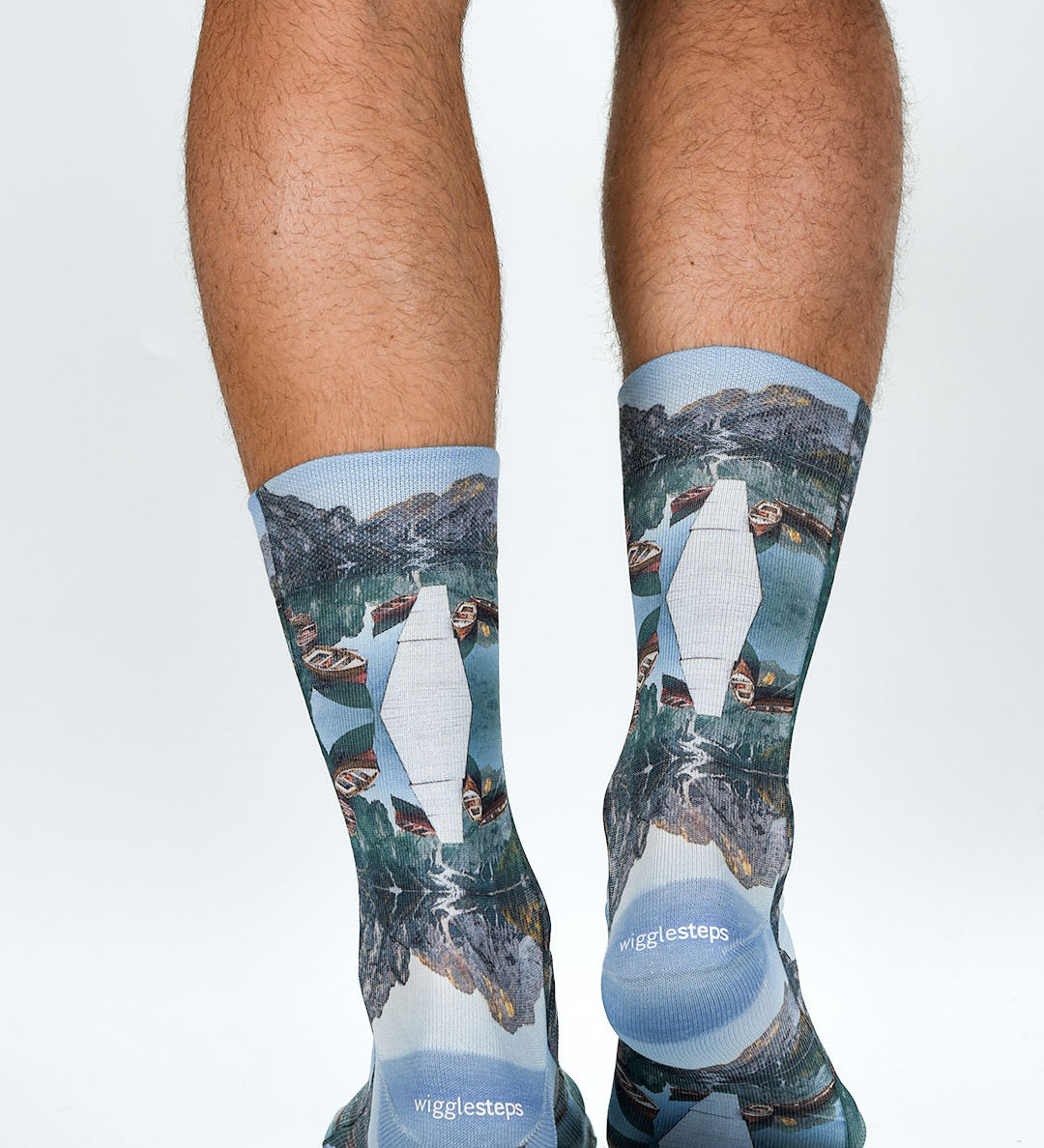 Person wearing socks with mountain and lake design on a white background