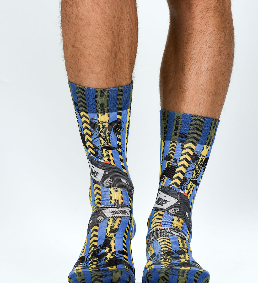 Colorful socks with a police theme socks pattern worn by a person on a light gray background