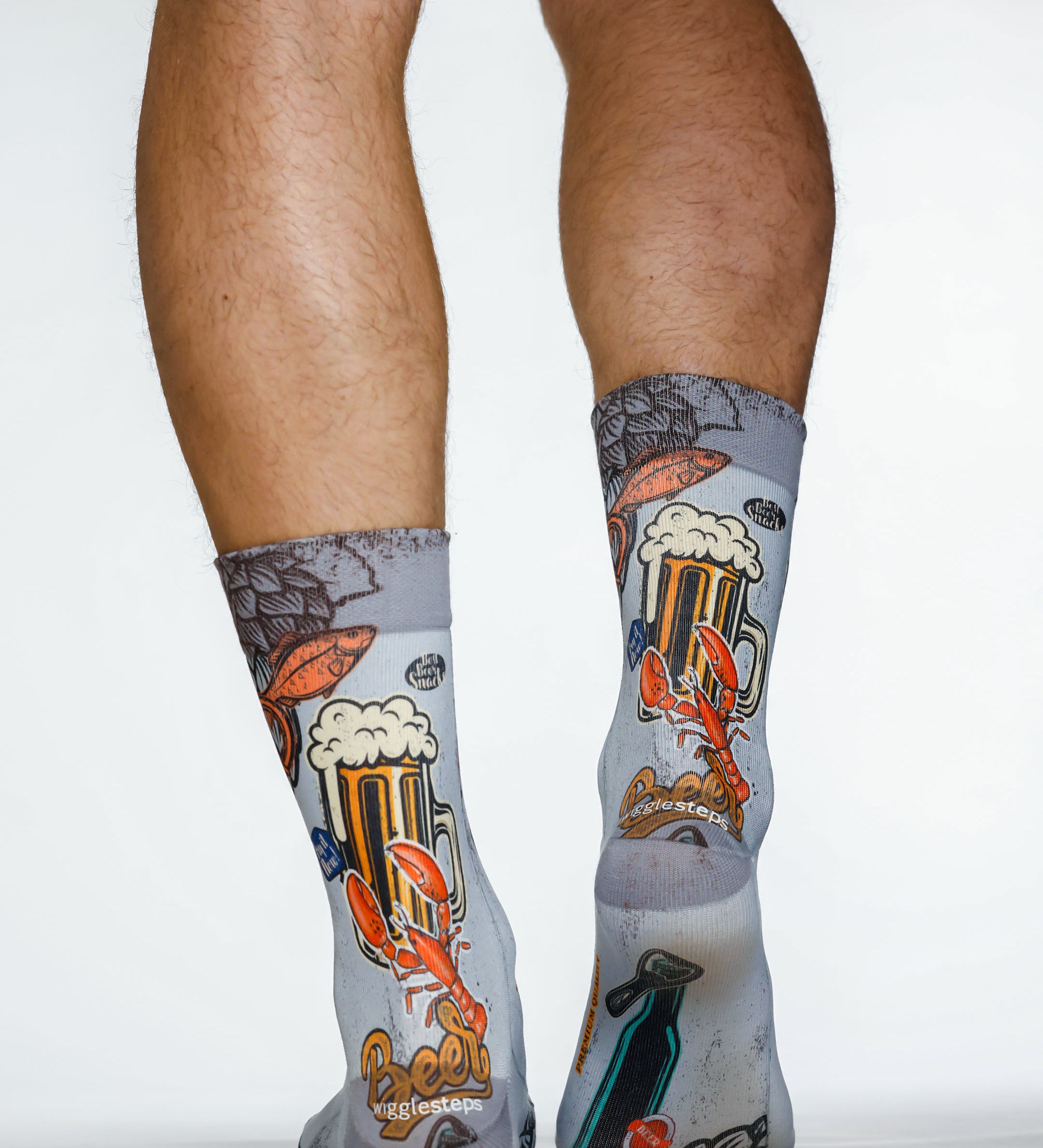 Gray socks with beer-themed design worn by a person on a white background