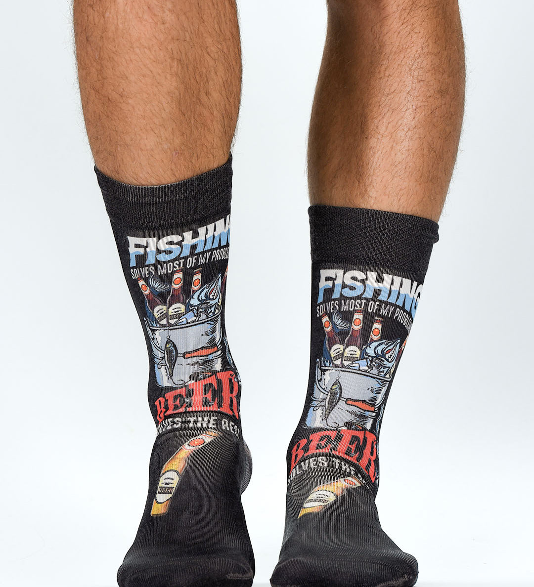 Black socks with fishing and beer-themed designs worn by a person on a white background