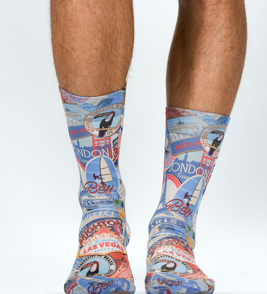 Colorful travel-themed socks worn by a person on a white background