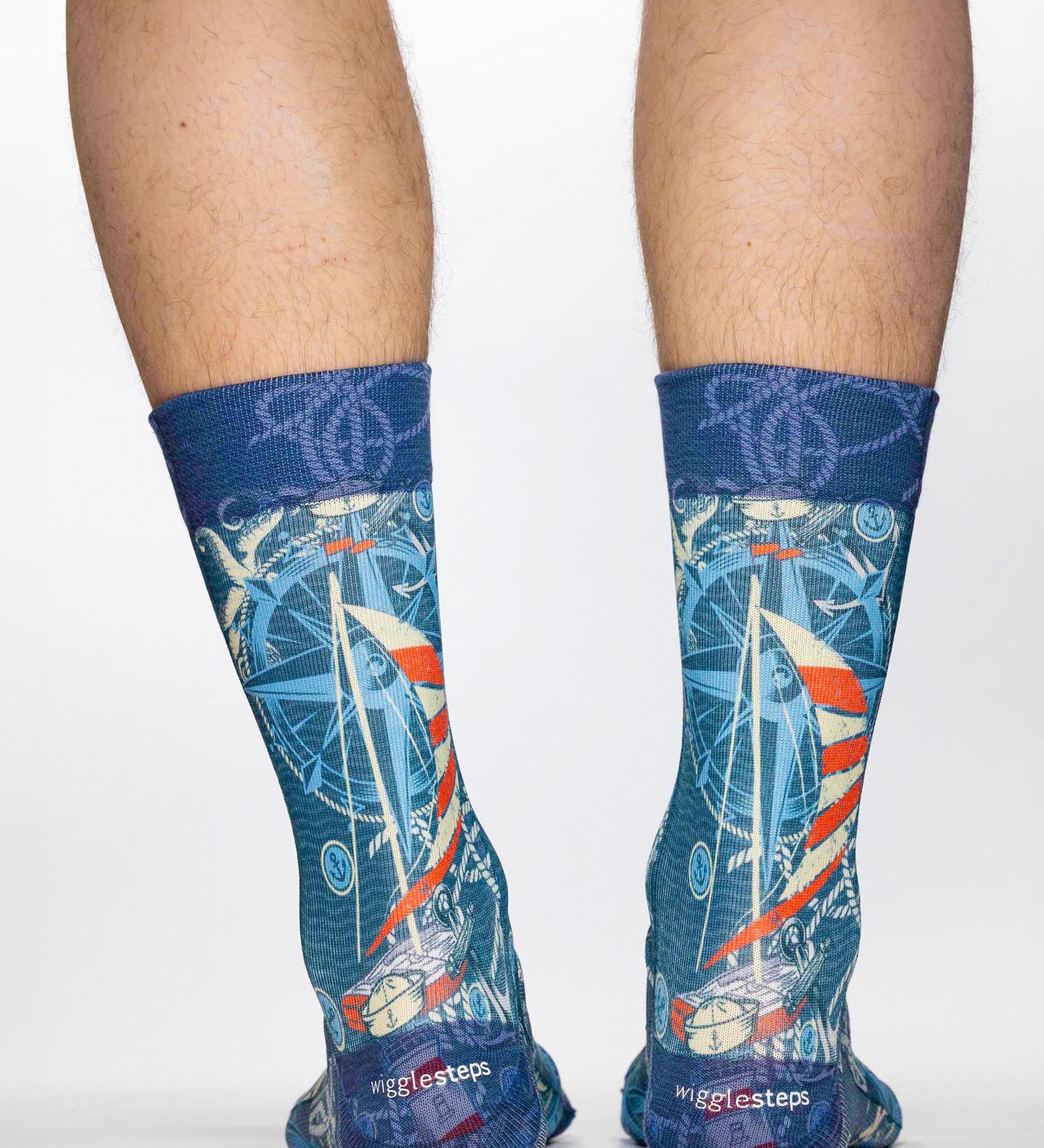 Blue socks with sailboat design worn by a person on a white background