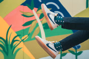 Person wearing nike sneakers against a colorful abstract wall with geometric design mens socks