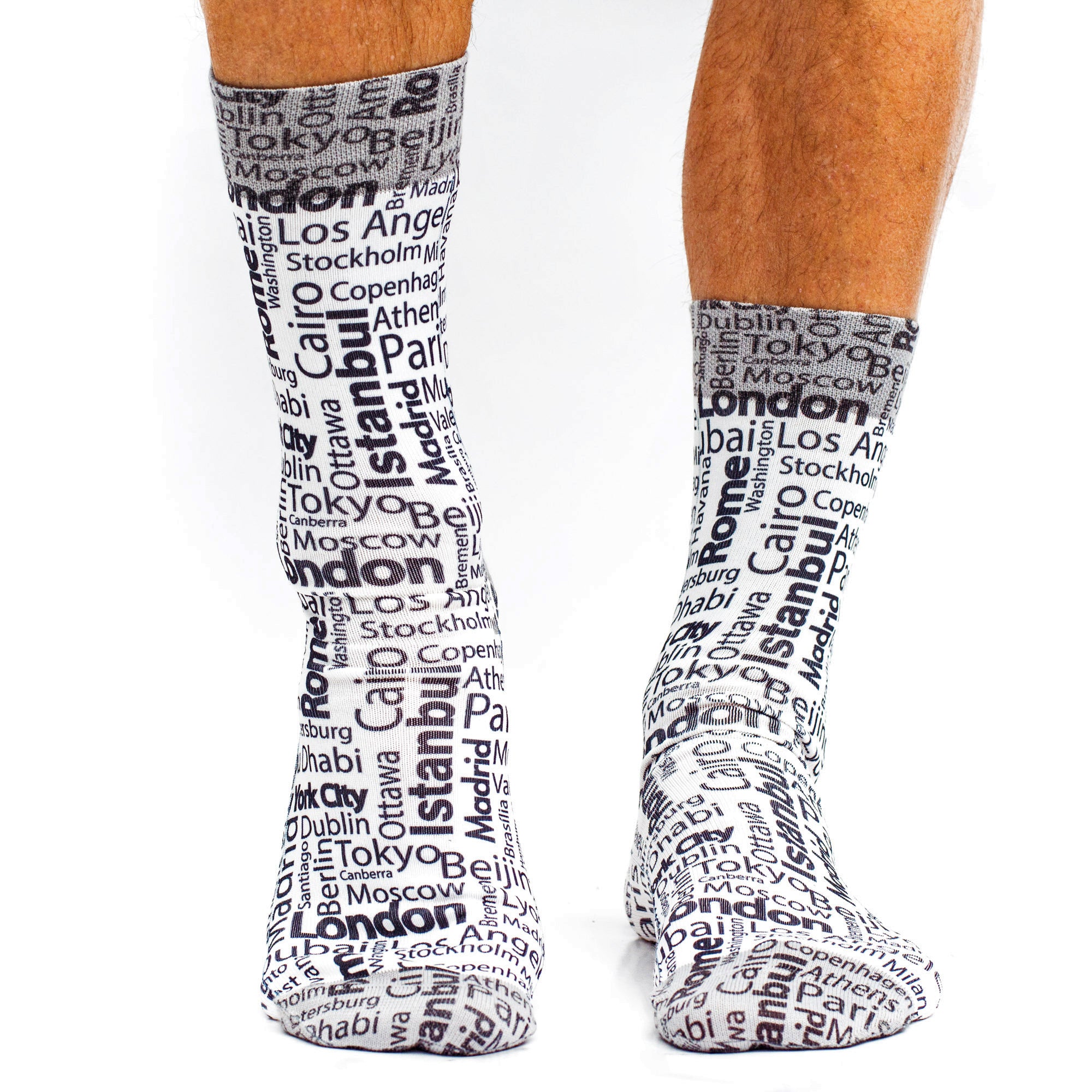 Socks with city names printed on them worn by a person.