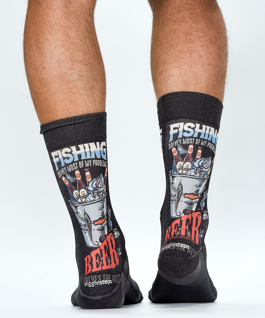 Black socks with fishing and beer-themed designs worn by a person on a white background