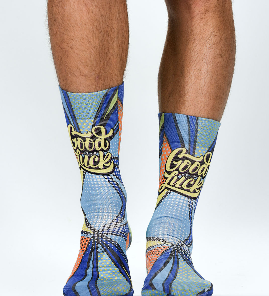Colorful socks with 'Good Luck' text worn by a person on a white background