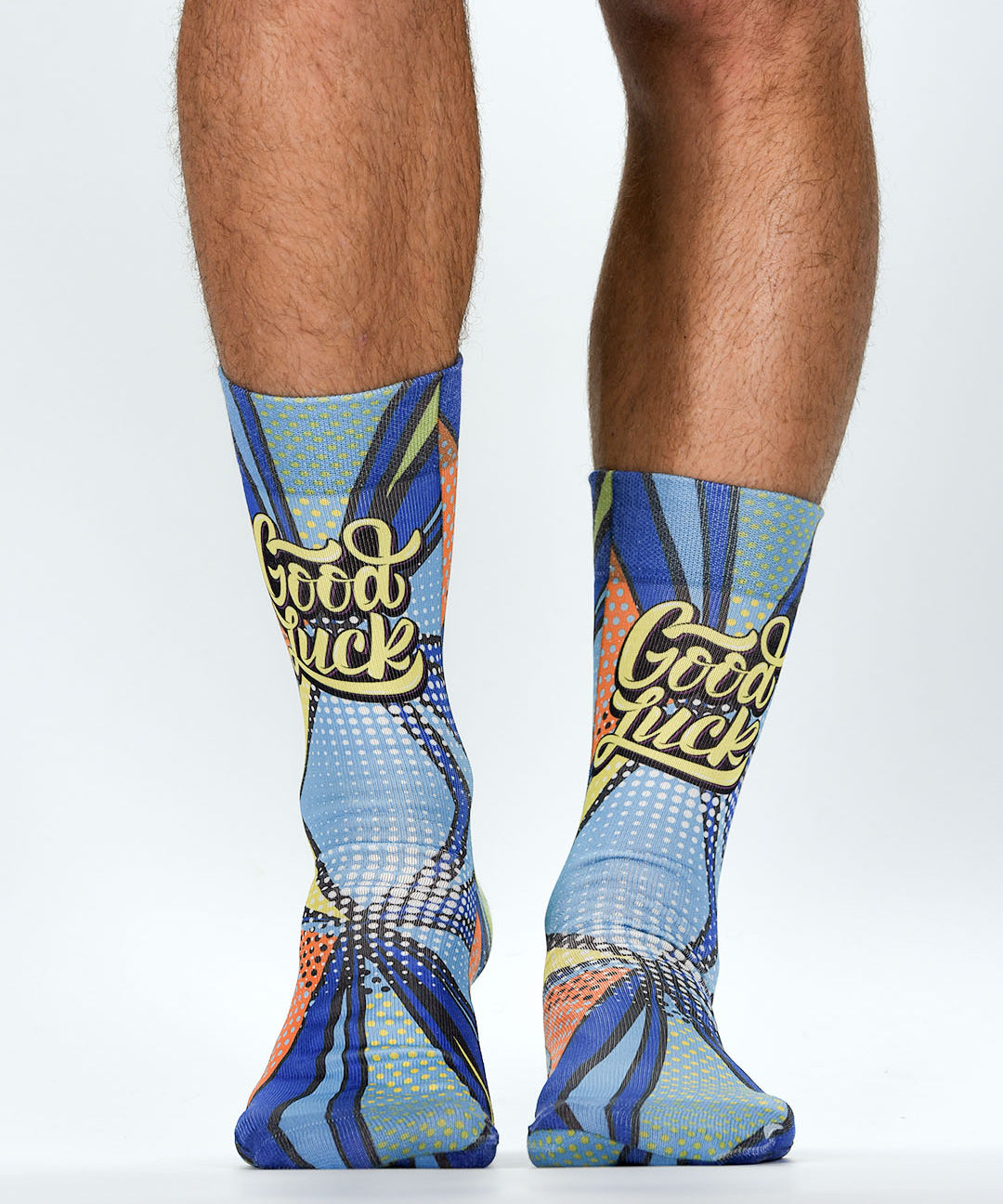 Colorful socks with 'Good Luck' text worn by a person on a white background