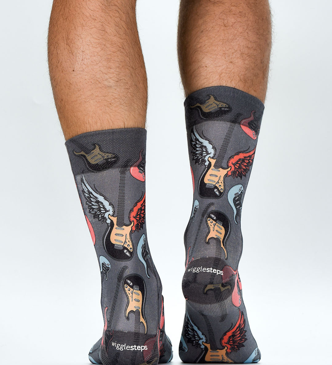 Person wearing socks with guitar and musician designs on a white background