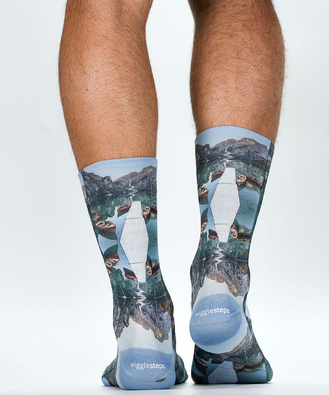 Person wearing socks with mountain and lake design on a white background