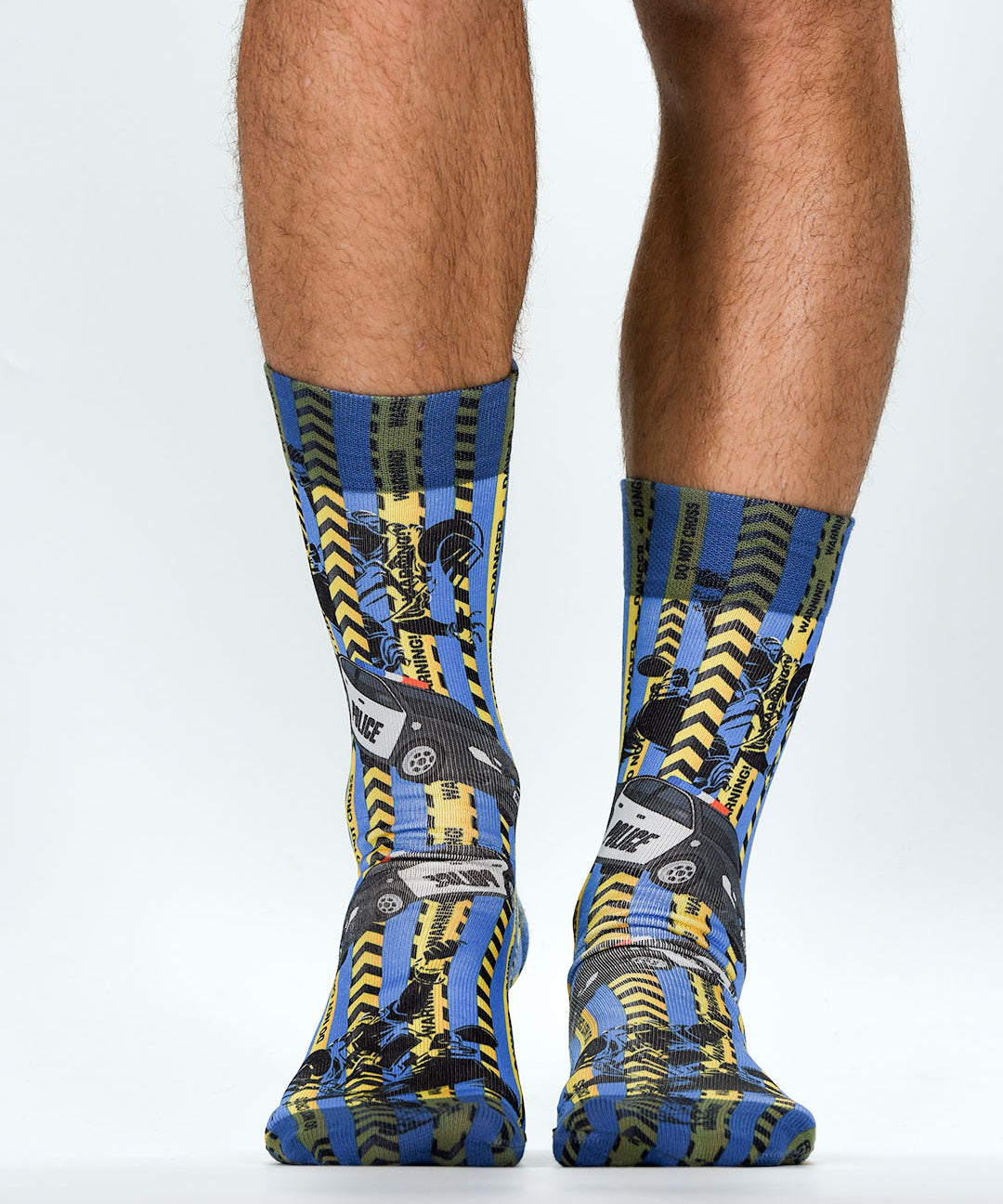 Colorful socks with a police theme socks pattern worn by a person on a light gray background