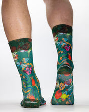 Green socks with colorful designs worn by a person on a white background