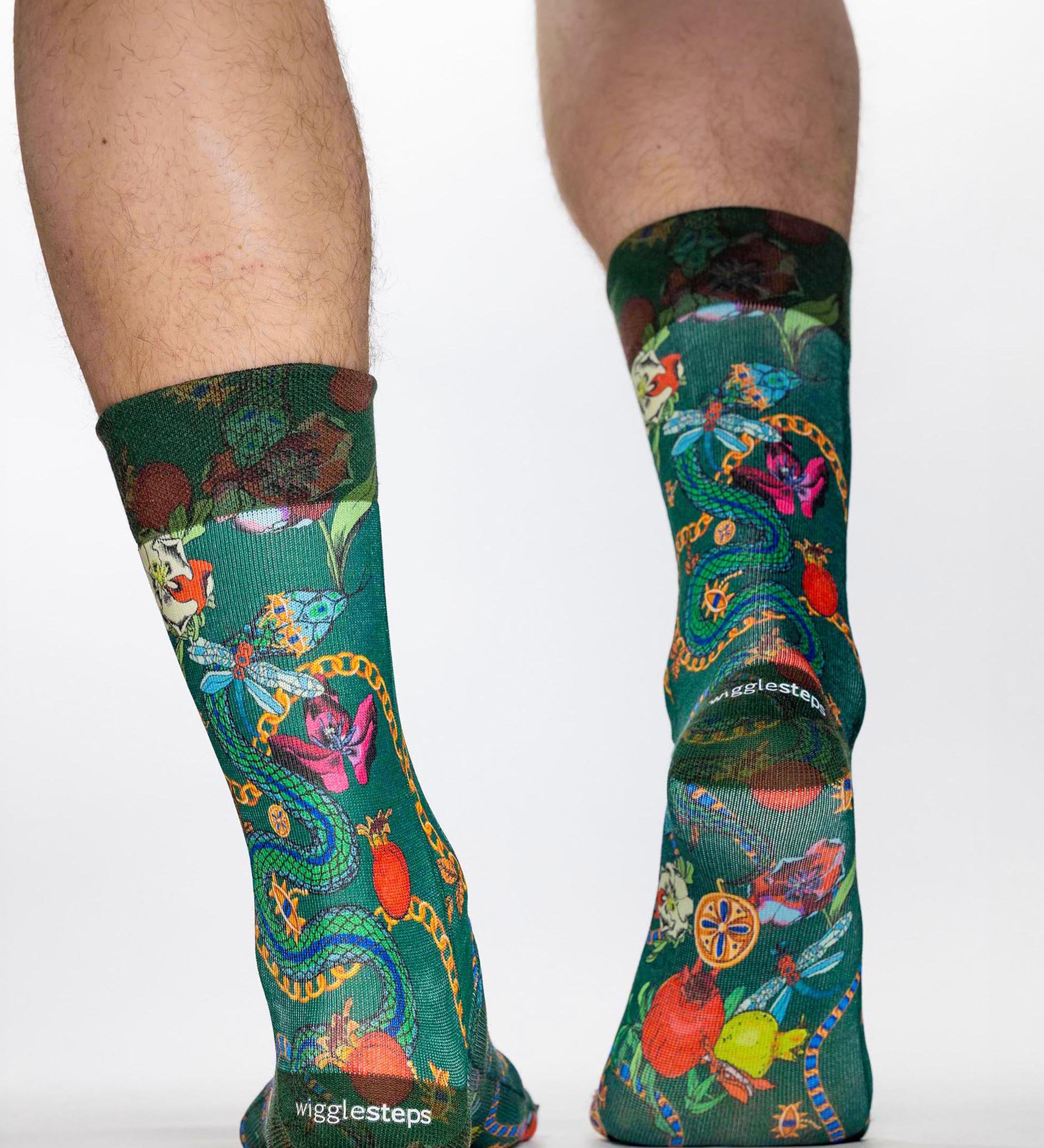 Green socks with colorful designs worn by a person on a white background
