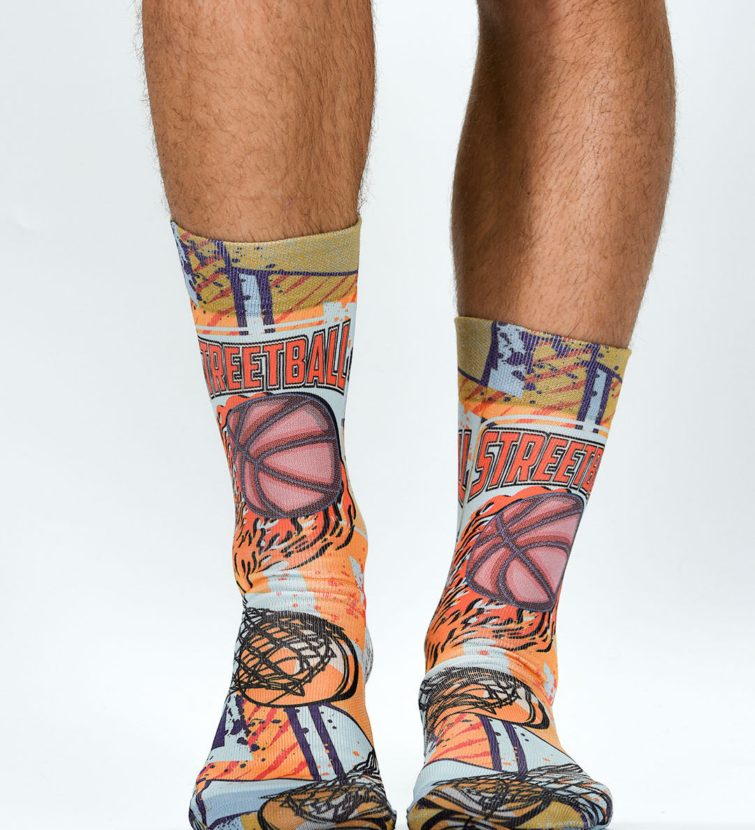 Colorful socks with basketball design worn by a person on a white background
