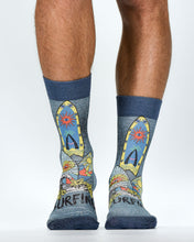 Colorful socks with surfboard design worn by a person on a white background