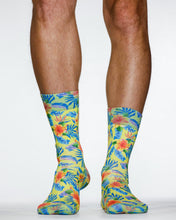 Colorful tropical patterned socks worn by a person on a white background