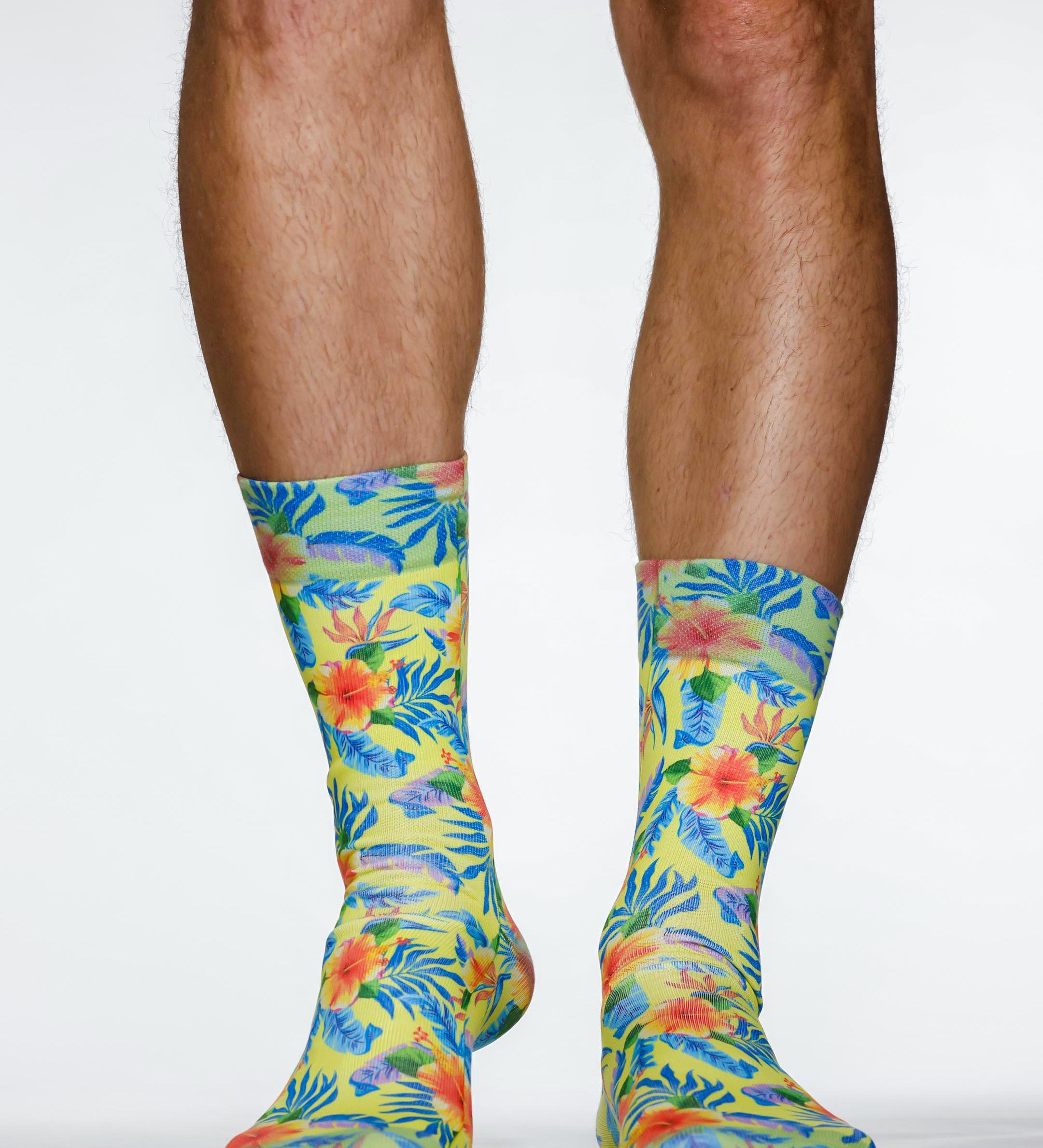 Colorful tropical patterned socks worn by a person on a white background