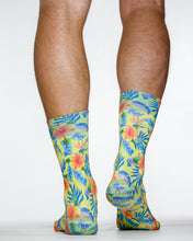 Colorful tropical leaf patterned socks on a plain background