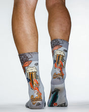 Gray socks with beer-themed design worn by a person on a white background