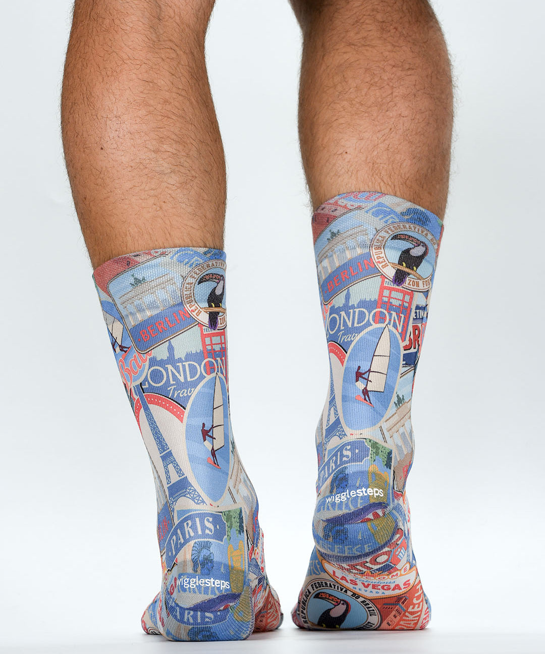 Colorful travel-themed socks with landmarks worn by a person on a white background