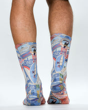 Colorful travel-themed socks with landmarks worn by a person on a white background