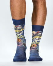Colorful socks with shark design and 'WIld Waves' text worn by a person on a white background
