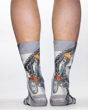 Gray socks with motorcycle design worn by a person on a white background