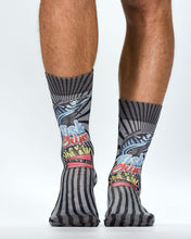 Colorful socks with abstract designs worn by a person on a white background