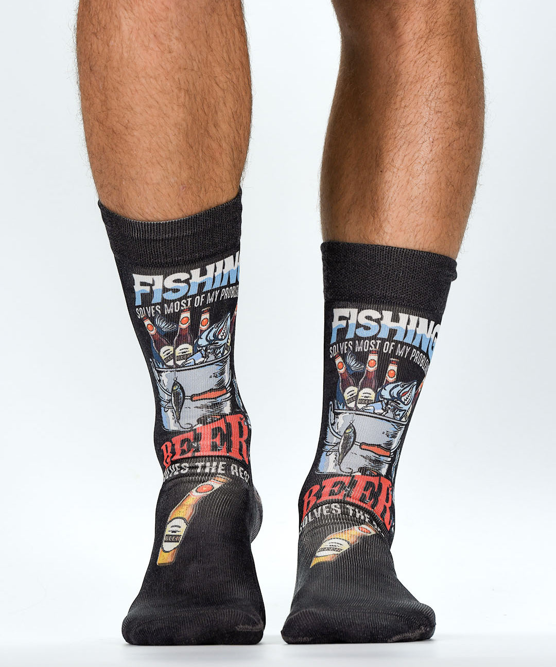 Black socks with fishing and beer-themed designs worn by a person on a white background