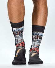 Black socks with fishing and beer-themed designs worn by a person on a white background