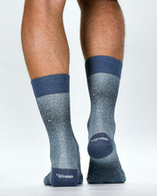 Gray socks with blue accents worn by a person on a white background