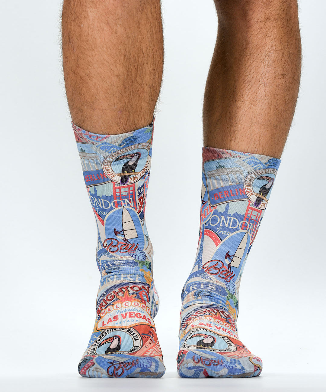 Colorful travel-themed socks worn by a person on a white background